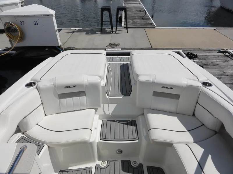 Slide: The Image of 2009 Sea Ray 250 SLX boat interior with white seating and dock view. - 11