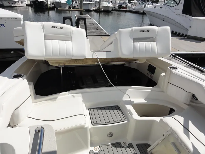 Slide: The Image of 2009 Sea Ray 250 SLX boat interior with open engine compartment at marina. - 19