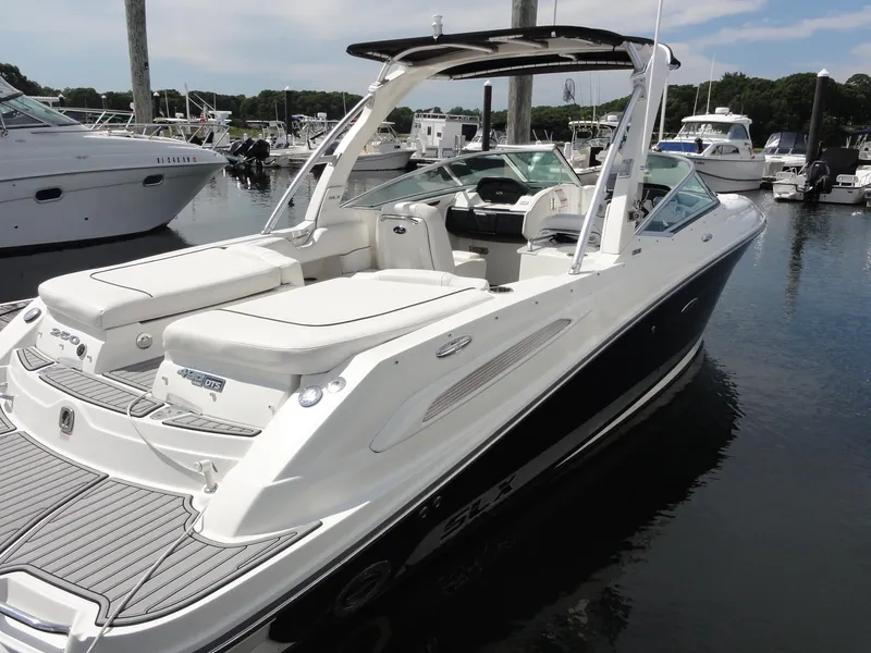 Slide: The Image of 2009 Sea Ray 250 SLX boat docked in a marina, featuring sleek design and spacious seating. - 5