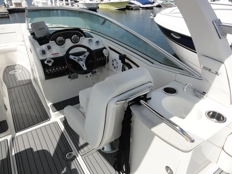 Slide: The Image of 2009 Sea Ray 250 SLX boat interior with steering wheel, dashboard, and seating at marina. - 9