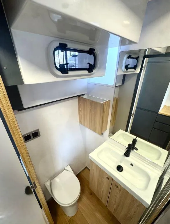 Slide: The Image of Compact bathroom in 2022 Navisyo Homes NV.08, featuring modern fixtures and wood accents. - 12