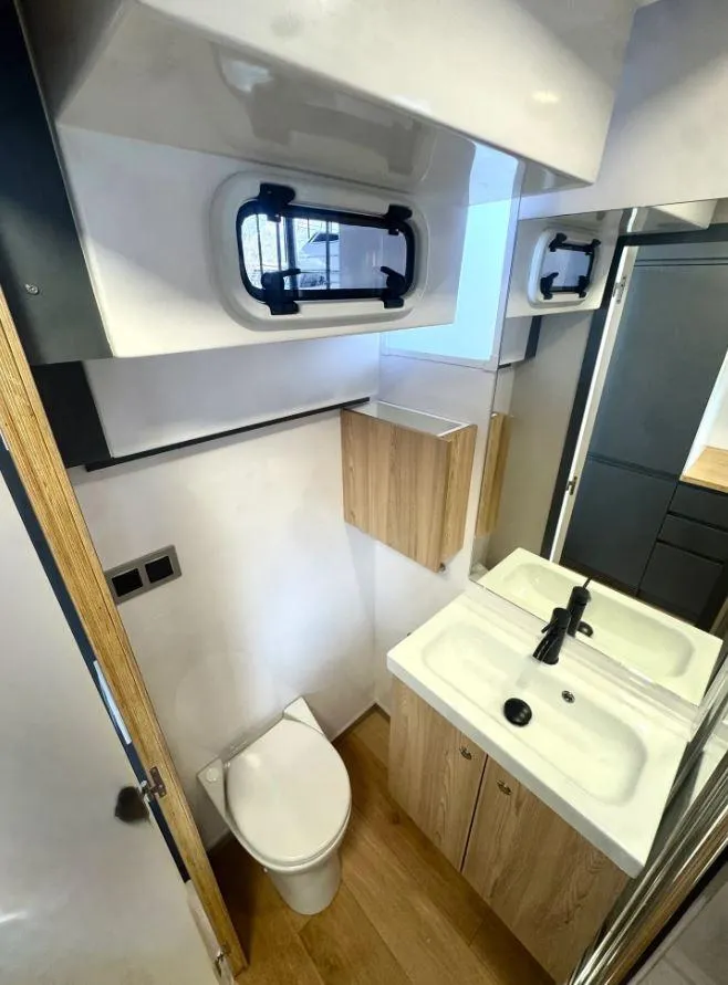 Slide: The Image of Modern bathroom in 2022 Navisyo Homes NV.08 with compact design and wooden accents. - 24