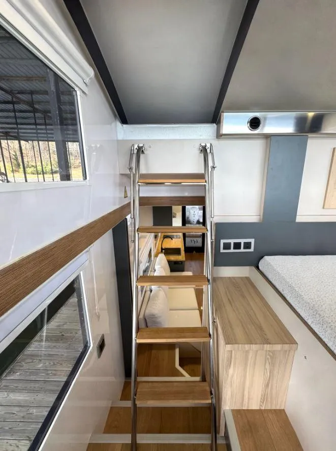 Slide: The Image of Modern Navisyo Homes NV.08 interior with wooden ladder, cozy seating, and bed, 2022 model. - 28