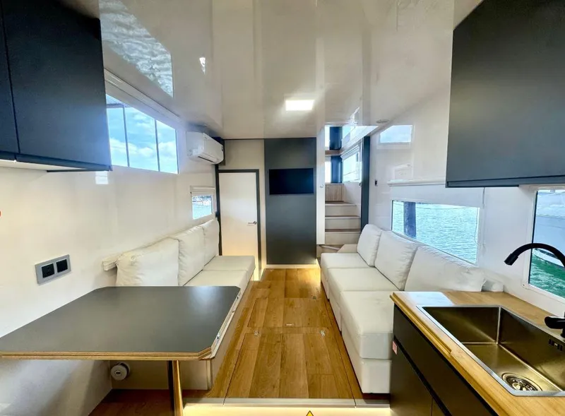 Slide: The Image of Modern Navisyo Homes NV.08 interior with sleek design, featuring sofas, table, and kitchenette, 2022 model. - 4