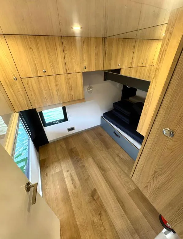 Slide: The Image of Compact wooden interior of Navisyo Homes NV.08, 2022 model, featuring storage cabinets and a window. - 5