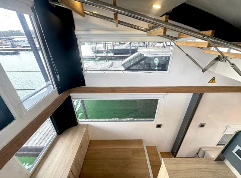 Slide: The Image of Modern interior of Navisyo Homes NV.08 houseboat, featuring sleek stairs and large windows, 2022 model. - 8