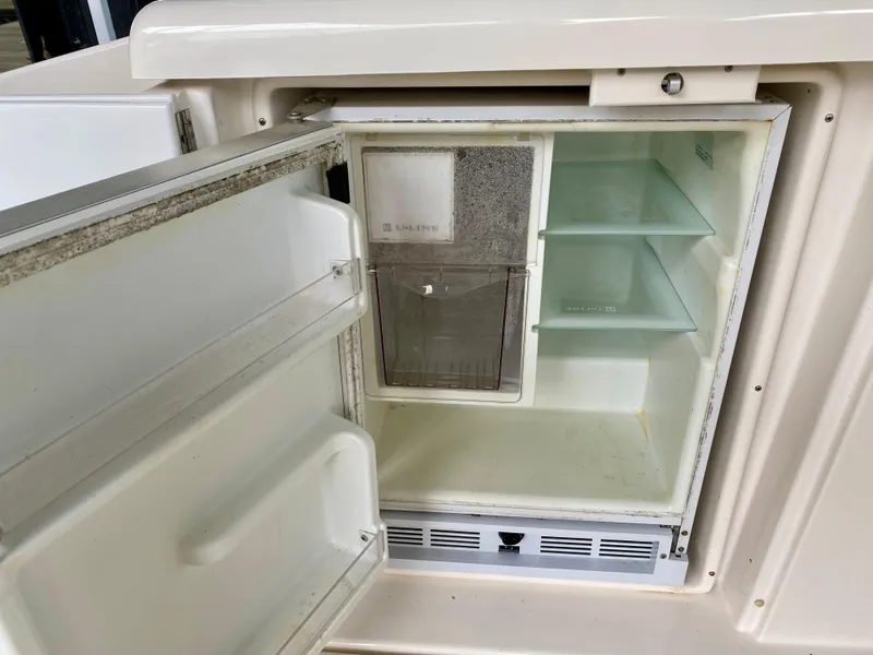 Slide: The Image of Open refrigerator on 2007 Cruisers Yachts 370 Express, showing shelves and ice compartment. - 12