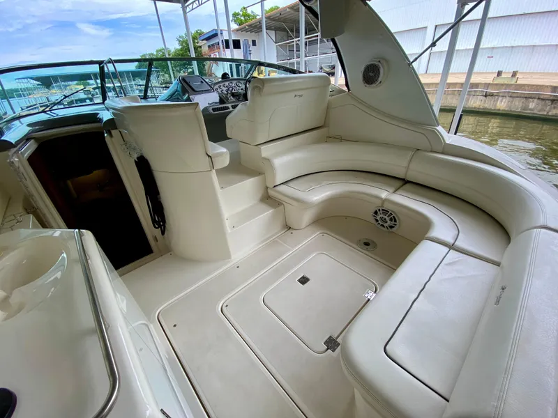 Slide: The Image of 2007 Cruisers Yachts 370 Express interior with white seating and helm, docked by the water. - 13