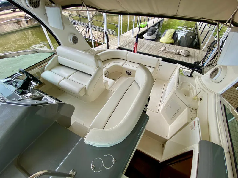 Slide: The Image of 2007 Cruisers Yachts 370 Express interior with white seating and helm, docked at marina. - 17