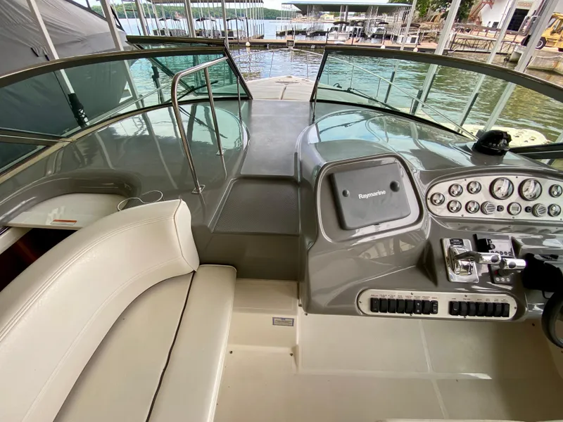 Slide: The Image of 2007 Cruisers Yachts 370 Express helm with Raymarine navigation, docked by the water. - 18