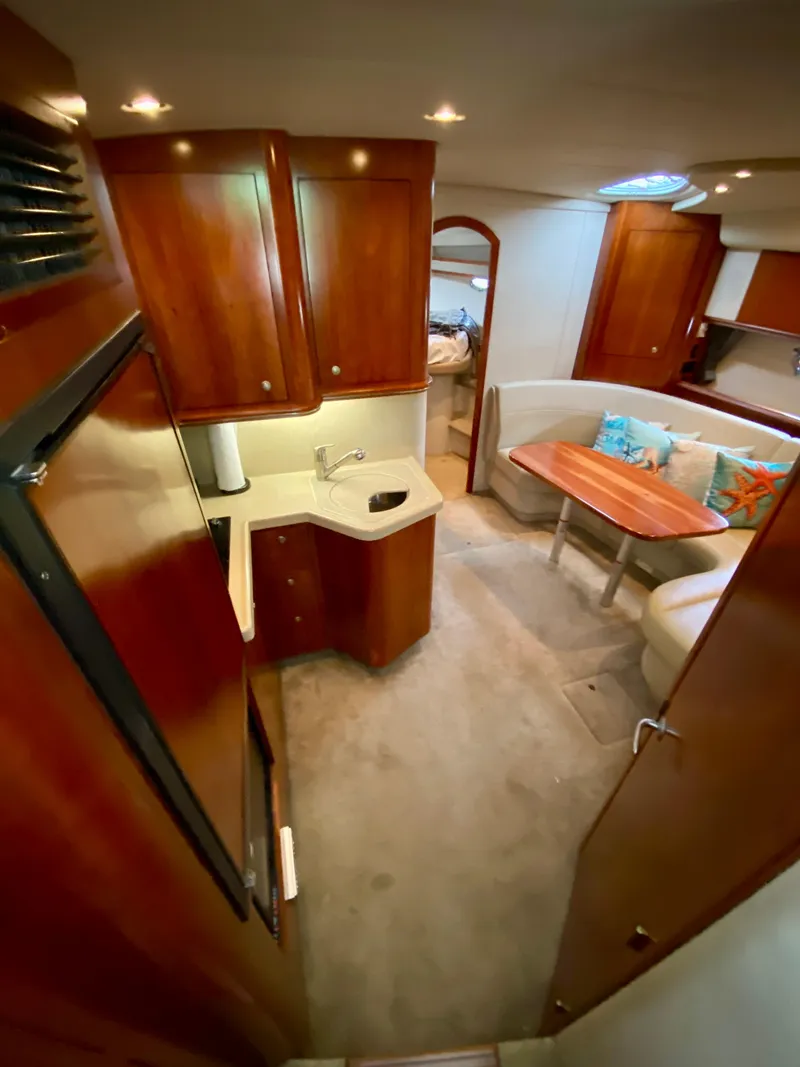 Slide: The Image of Interior of 2007 Cruisers Yachts 370 Express, featuring wood cabinetry and cozy seating area. - 32