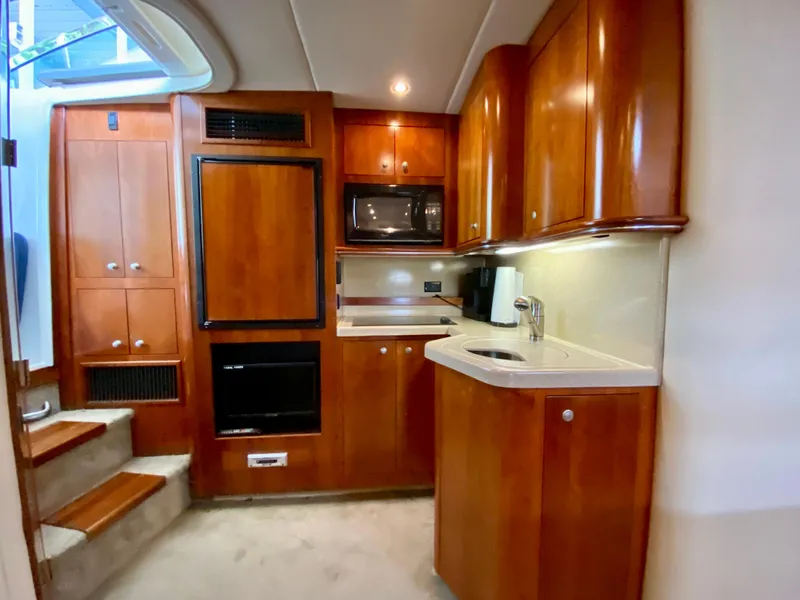 Slide: The Image of 2007 Cruisers Yachts 370 Express interior with wooden cabinetry and modern kitchen amenities. - 35