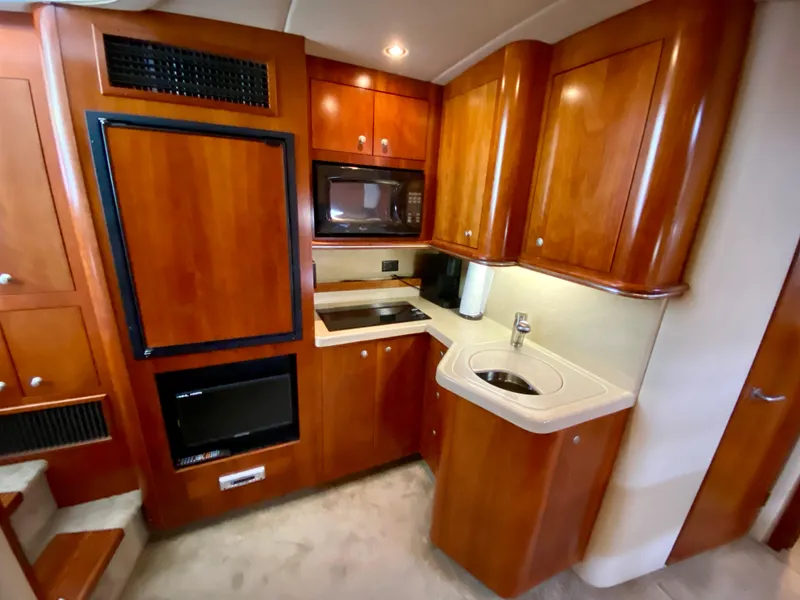 Slide: The Image of 2007 Cruisers Yachts 370 Express kitchen with wood cabinetry, microwave, and sink. - 36