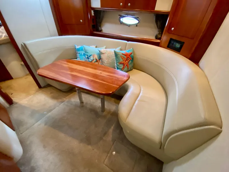 Slide: The Image of 2007 Cruisers Yachts 370 Express interior with curved seating and wooden table. - 37