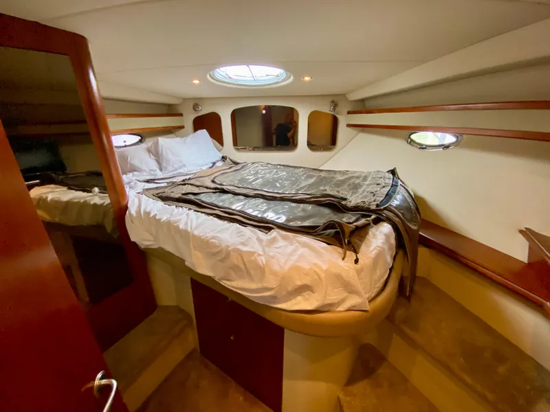 Slide: The Image of 2007 Cruisers Yachts 370 Express cabin with bed, wood accents, and porthole windows. - 39