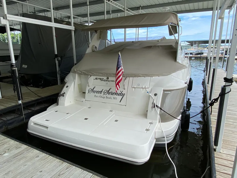 Slide: The Image of 2007 Cruisers Yachts 370 Express docked, covered, with American flag, named "Sweet Serenity." - 4
