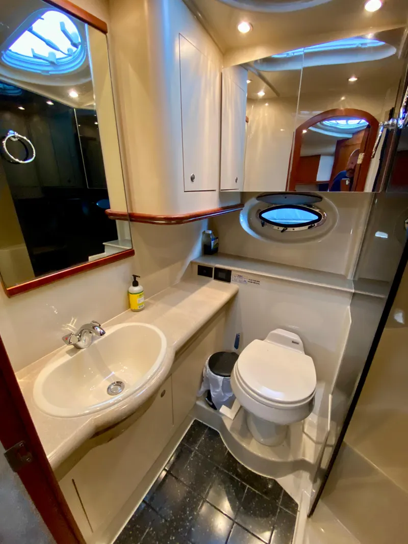 Slide: The Image of 2007 Cruisers Yachts 370 Express bathroom with sink, toilet, and porthole window. - 42