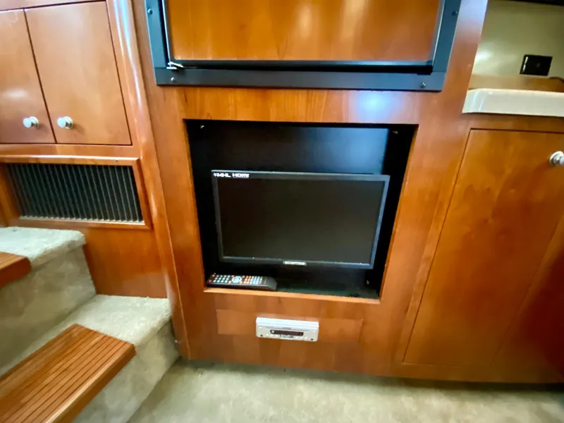 Slide: The Image of 2007 Cruisers Yachts 370 Express interior with built-in TV and wooden cabinetry. - 44