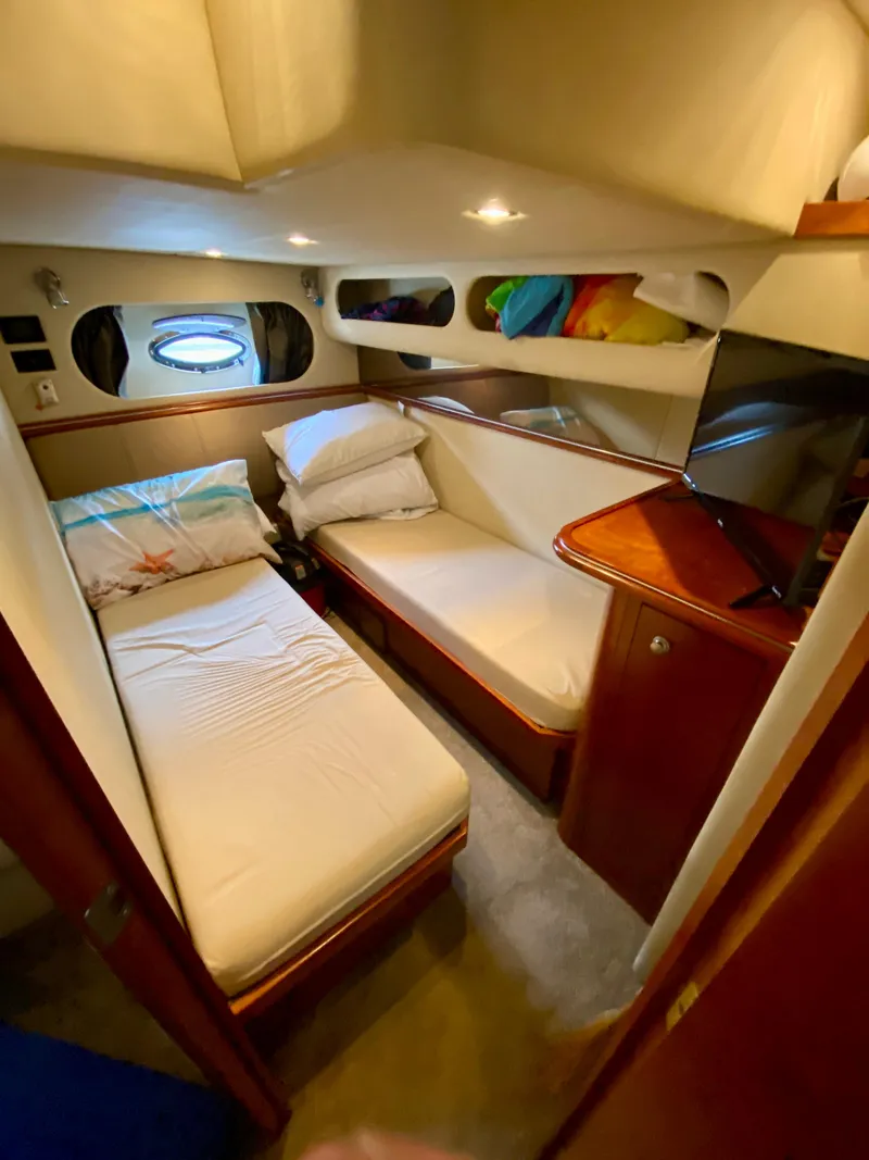 Slide: The Image of 2007 Cruisers Yachts 370 Express cabin with twin beds, porthole, and TV. - 47