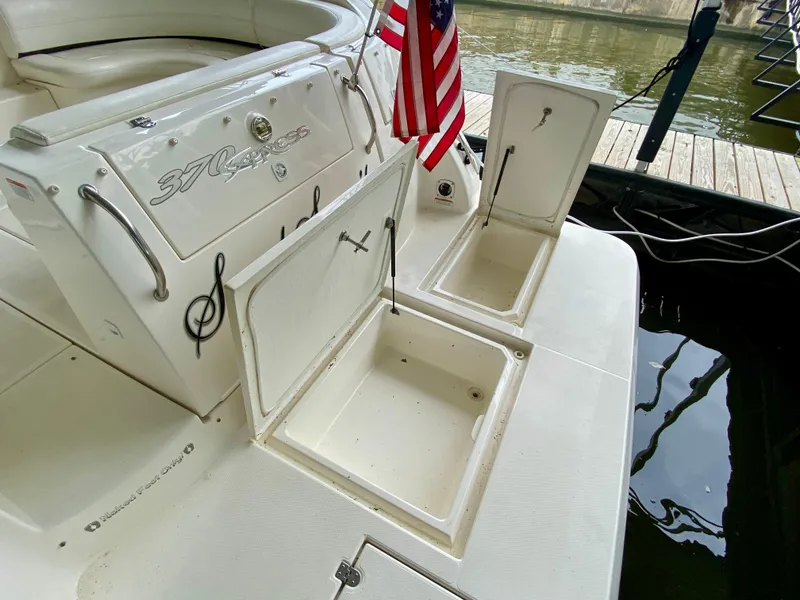 Slide: The Image of 2007 Cruisers Yachts 370 Express with open storage compartments and American flag at dock. - 7
