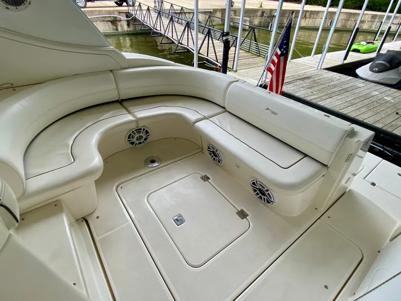 Slide: The Image of 2007 Cruisers Yachts 370 Express interior with white seating and speakers, docked by the water. - 8