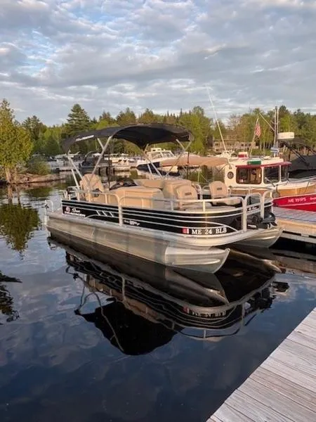 Slide: The Image of 2021 Sun Tracker FB 20 DLX pontoon boat docked on a calm lake. - 13