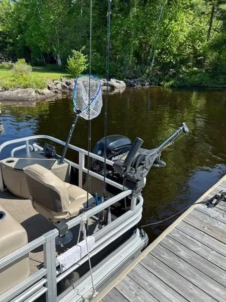 Slide: The Image of 2021 Sun Tracker FB 20 DLX pontoon boat docked by a serene lake. - 15