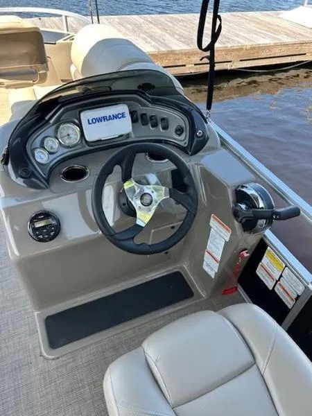 Slide: The Image of 2021 Sun Tracker FB 20 DLX boat dashboard with steering wheel and Lowrance display. - 3