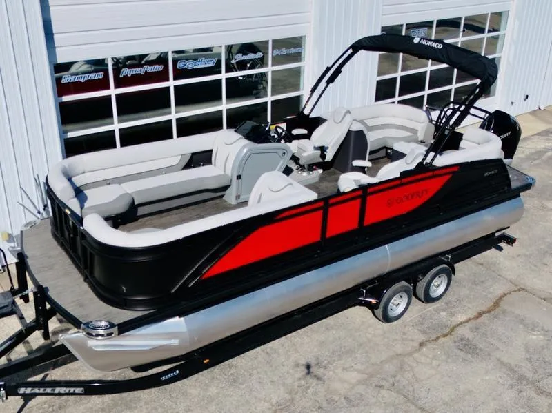 Slide: The Image of 2025 Godfrey Monaco 255 SB iMPACT pontoon boat with red and black design on trailer. - 13