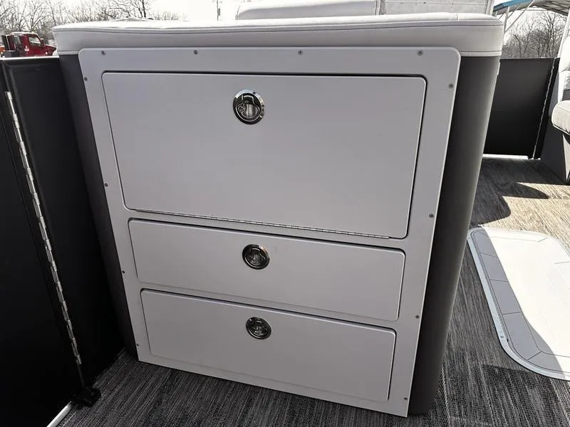 Slide: The Image of 2025 Godfrey Monaco 255 SB iMPACT Package storage compartment with three drawers on a boat deck. - 16