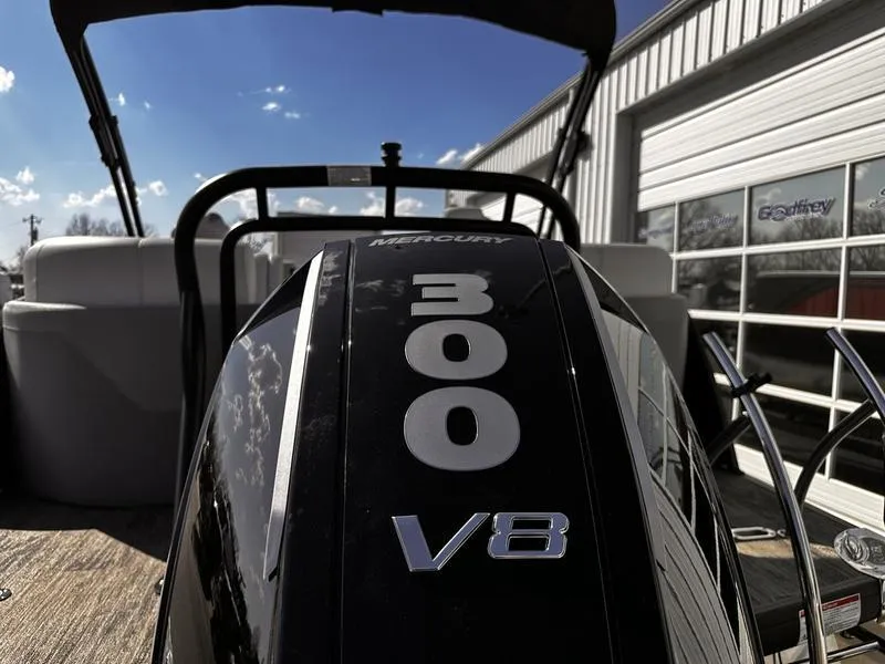 Slide: The Image of 2025 Godfrey Monaco 255 SB with Mercury 300 V8 engine, docked near a building. - 6