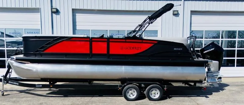 Slide: The Image of 2025 Godfrey Monaco 255 SB iMPACT pontoon boat on trailer, red and black design. - 8