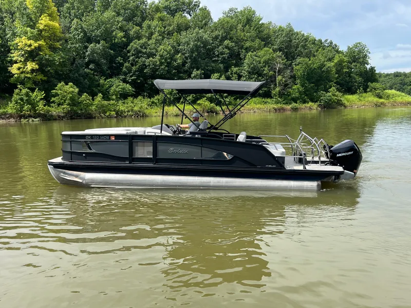 Slide: The Image of 2024 Barletta Lusso 23UC pontoon boat on a calm lake with lush green trees. - 3