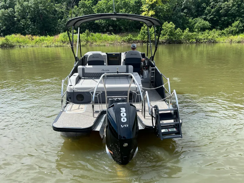 Slide: The Image of 2024 Barletta Lusso 23UC pontoon boat on a calm river, featuring a powerful Mercury 300 V8 engine. - 4