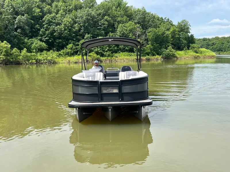 Slide: The Image of 2024 Barletta Lusso 23UC pontoon boat on a calm lake with lush greenery. - 6