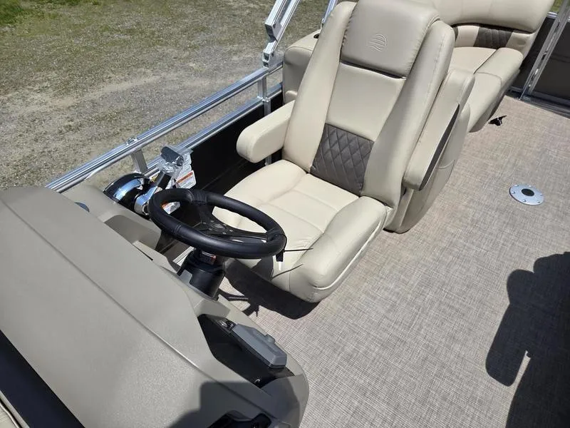 Slide: The Image of 2025 Sun Tracker PARTY BARGE® 22 DLX interior with beige captain's chair and steering wheel. - 11