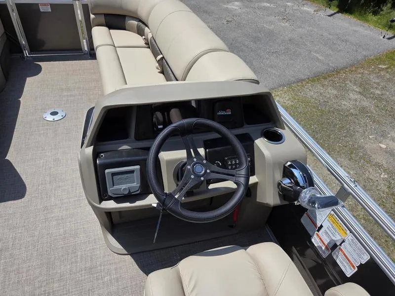 Slide: The Image of 2025 Sun Tracker PARTY BARGE® 22 DLX boat interior with steering wheel and beige seating. - 12