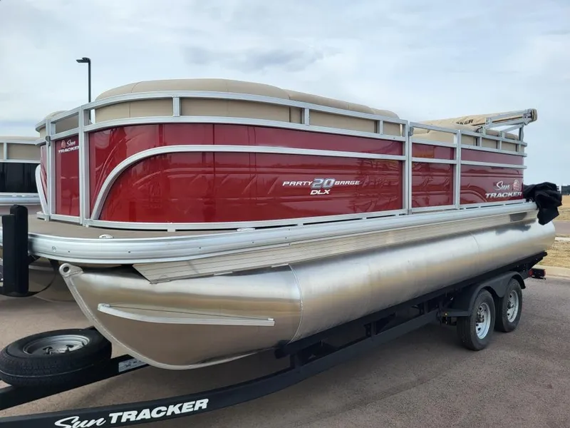 Slide: The Image of 2025 Sun Tracker Party Barge 20 DLX pontoon boat on trailer, red and silver design. - 3