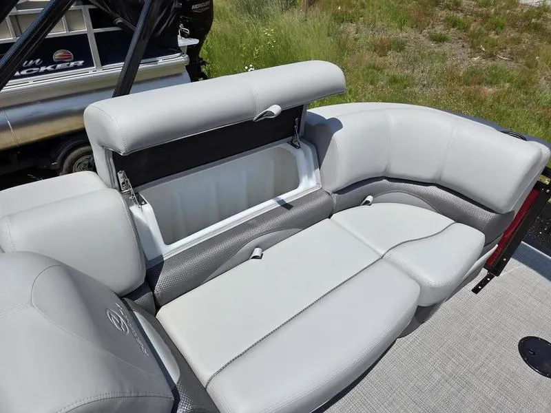 Slide: The Image of 2025 Regency 230 DL3 boat with open storage compartment on gray cushioned seating. - 12