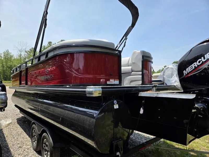Slide: The Image of 2025 Regency 230 DL3 pontoon boat with Mercury engine, parked on a trailer. - 5