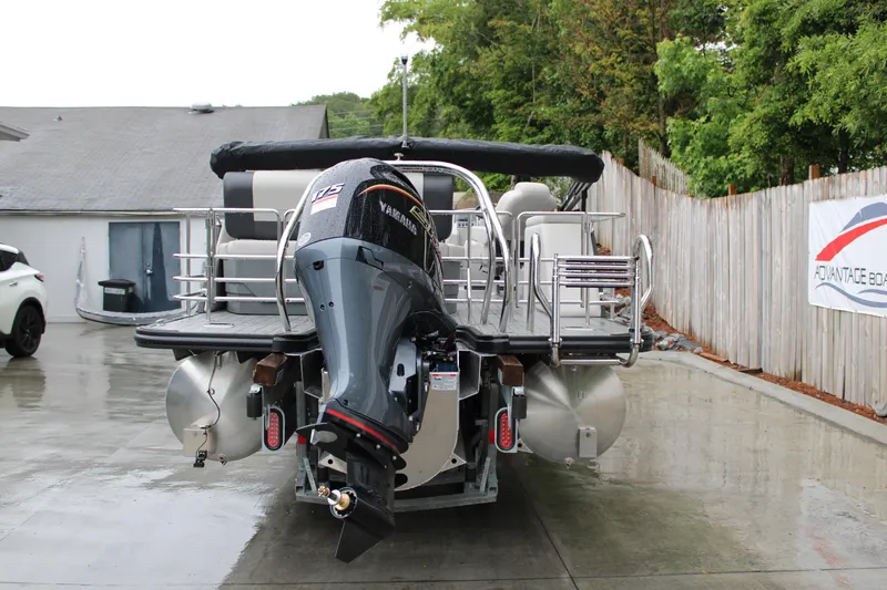 Slide: The Image of 2025 Starcraft EXS 3 DL pontoon boat with Yamaha outboard motor, parked on wet driveway. - 3