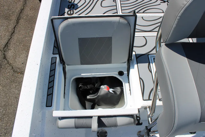 Slide: The Image of 2026 Xpress H22B Bay boat seat with storage compartment open, showing interior details. - 15