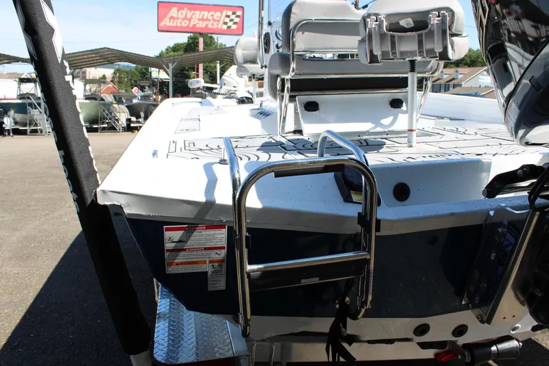 Slide: The Image of 2026 Xpress H22B Bay boat with ladder, parked near Advance Auto Parts sign. - 17