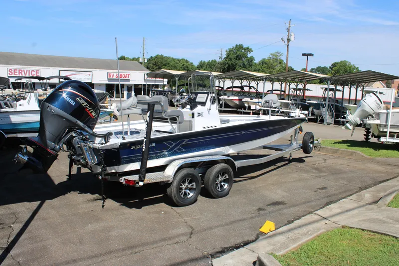 Slide: The Image of 2026 Xpress H22B Bay boat on trailer at dealership, featuring Yamaha outboard motor. - 4