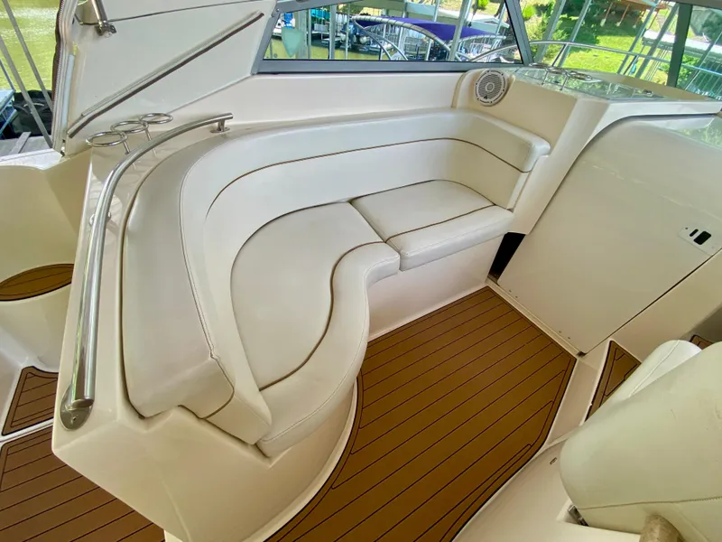 Slide: The Image of 2006 Rinker 360 Fiesta Vee boat interior with white seating and wood flooring. - 10