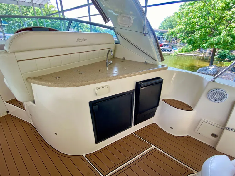 Slide: The Image of 2006 Rinker 360 Fiesta Vee boat interior with kitchenette, featuring sink and mini fridge. - 11