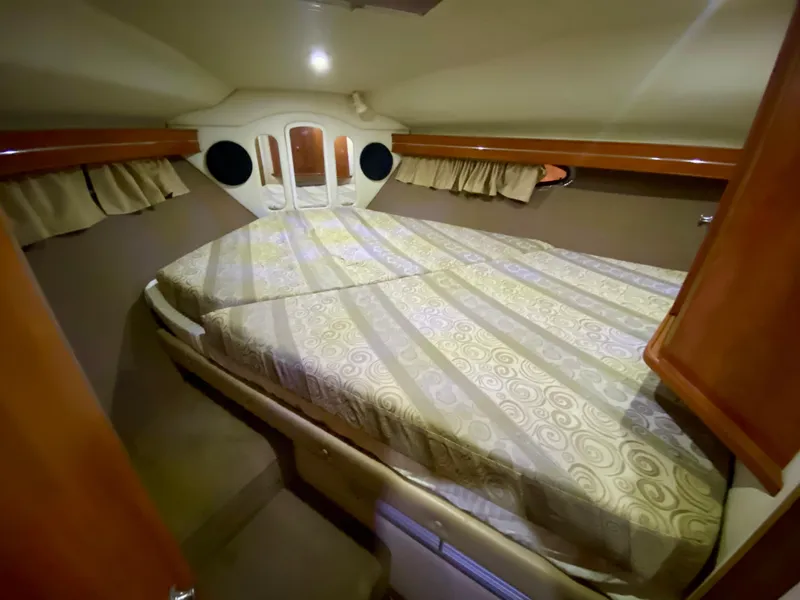 Slide: The Image of 2006 Rinker 360 Fiesta Vee cabin interior with double bed and wood accents. - 31