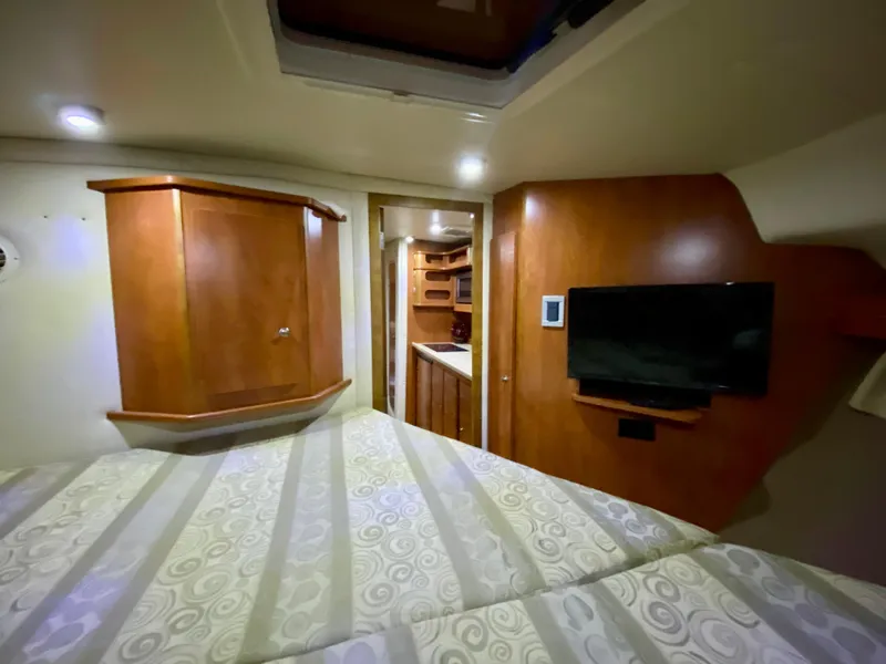 Slide: The Image of Interior of 2006 Rinker 360 Fiesta Vee boat with wood cabinetry and mounted TV. - 32