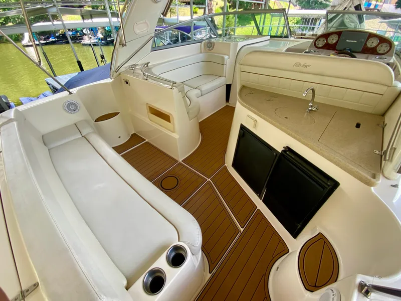 Slide: The Image of 2006 Rinker 360 Fiesta Vee boat interior with seating, kitchenette, and wood-style flooring. - 8