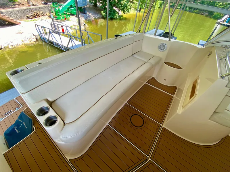 Slide: The Image of 2006 Rinker 360 Fiesta Vee boat interior with cushioned seating and wood-patterned flooring. - 9